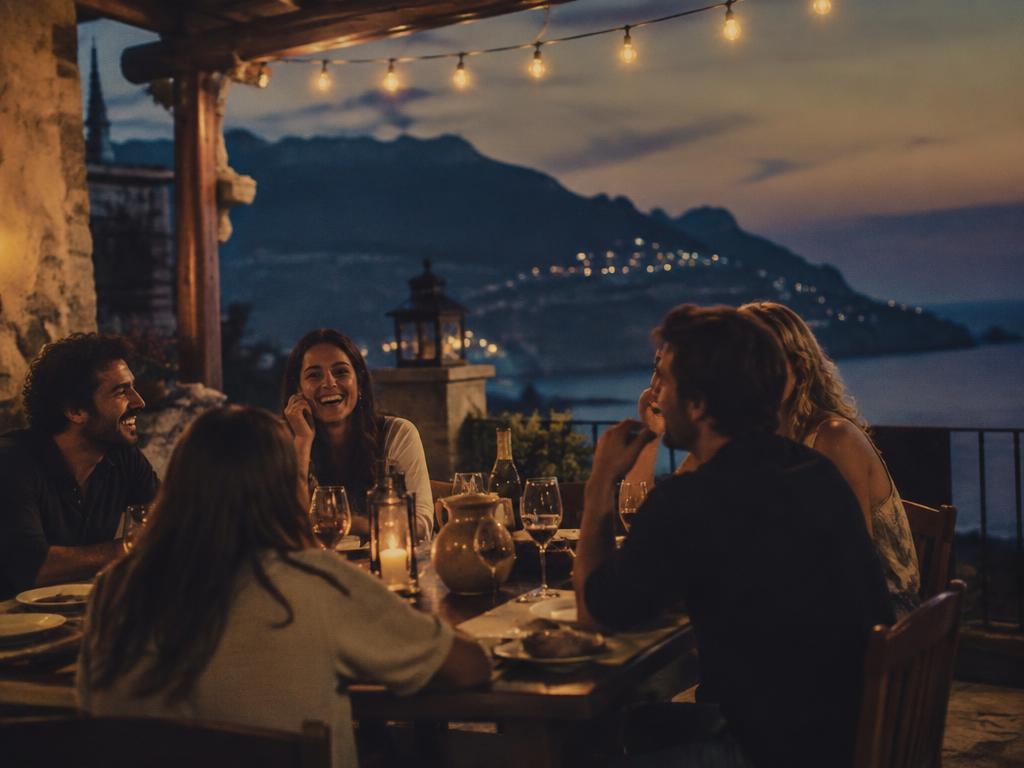 Friends sharing dinner on a terrace at dusk